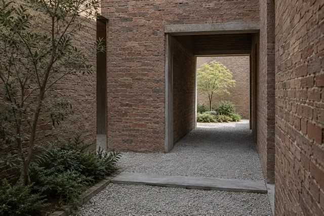 Staggered brick portals opening onto a small planted courtyard.
