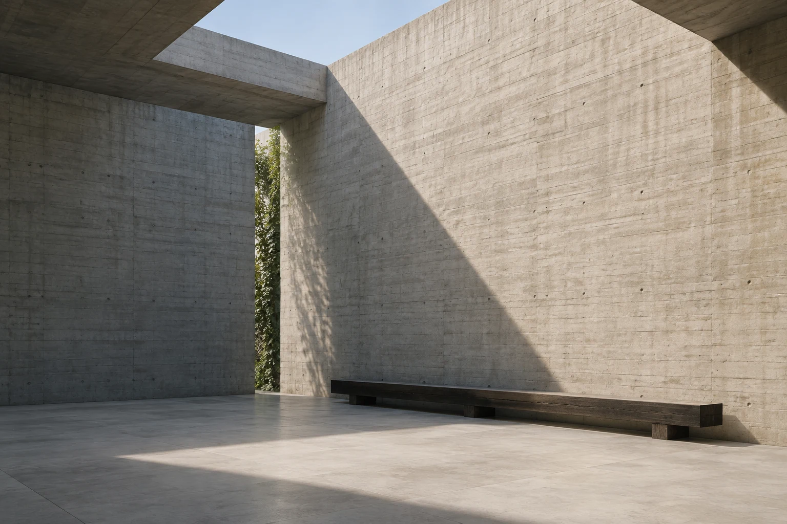 Pale concrete court open to the sky, with a long timber bench and a diagonal shadow.